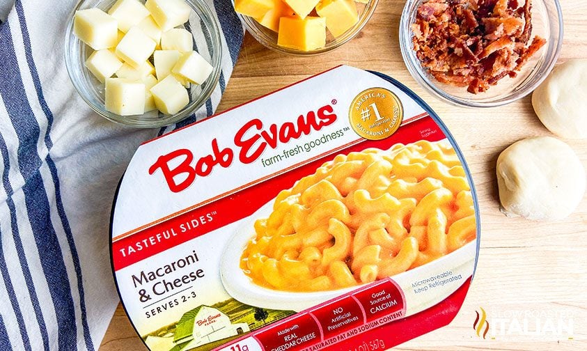 package of Bob Evans Mac and Cheese surrounded by dough balls, cubed cheese, and bacon crumbles