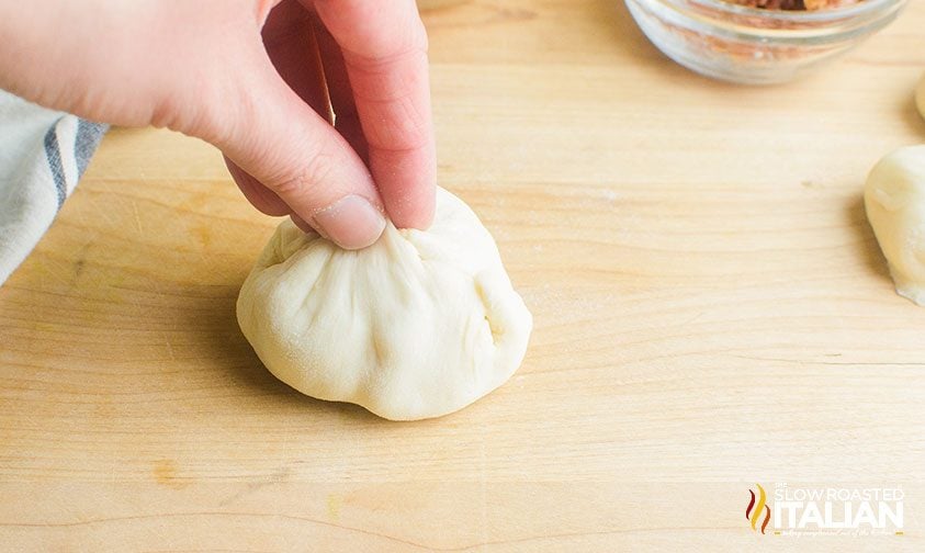 pinching stuffed dough ball shut