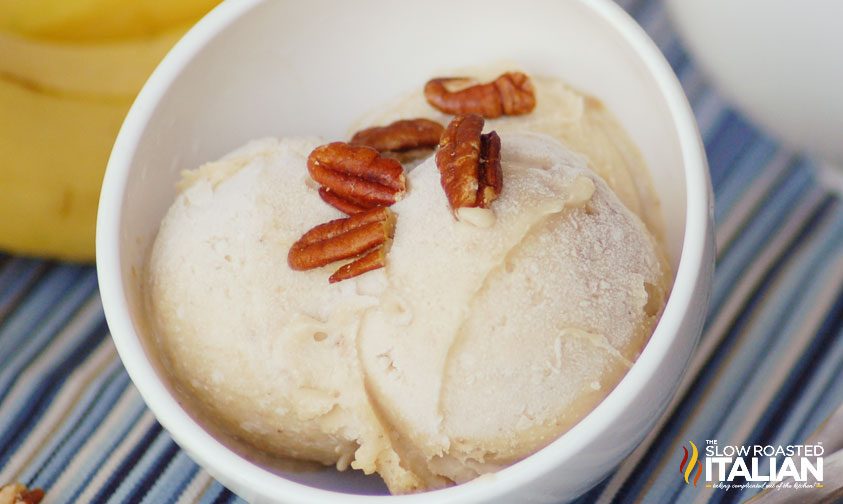 two scoops of banana nut ice cream topped with pecans in a bowl