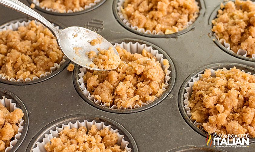 crumble topping being spooned onto muffin