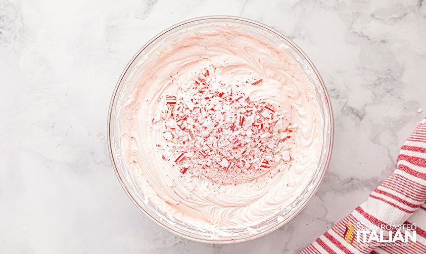 crushed peppermint candies in bowl of cheesecake filling