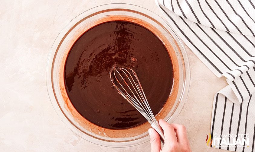 whisking brownie batter in bowl