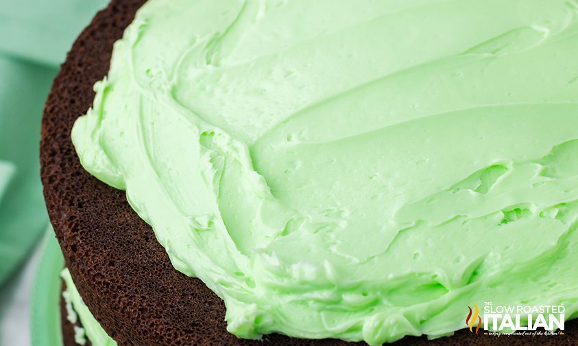 homemade mint frosting spread onto chocolate cake layers