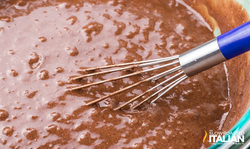 whisk in a bowl of chocolate cake batter