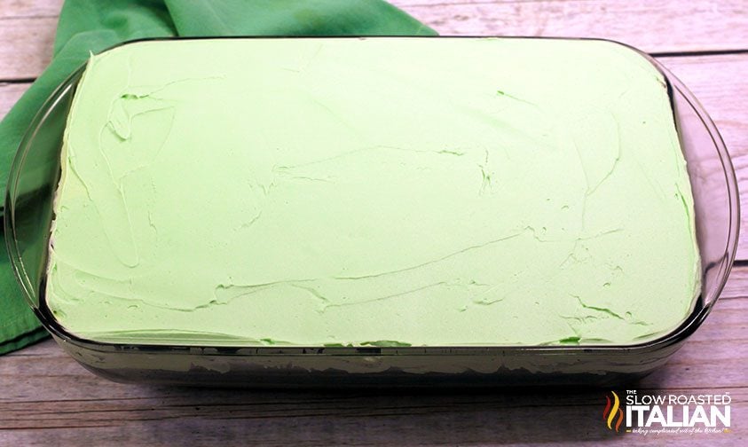 green mint frosting smoothed over chocolate cake