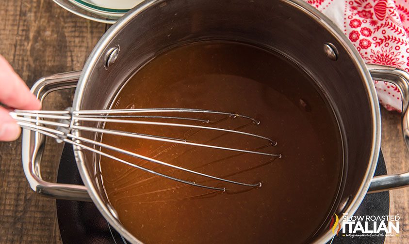 whisking sweet and sour sauce in pan