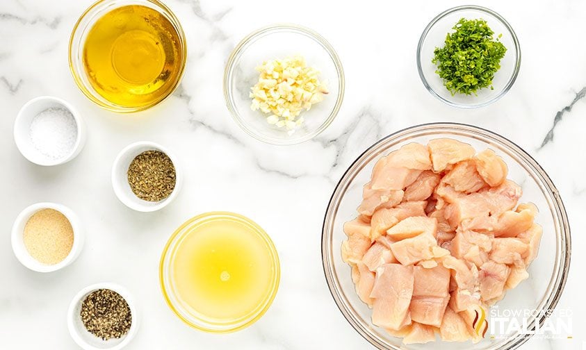 bowls of cubed chicken, oil, lemon juice, garlic, and seasonings