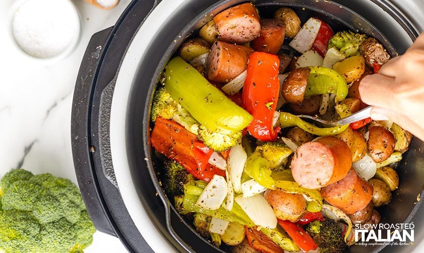 stirring air fryer sausage and veggies