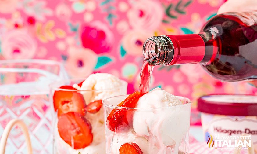 pouring wine over ice cream and strawberries in glass