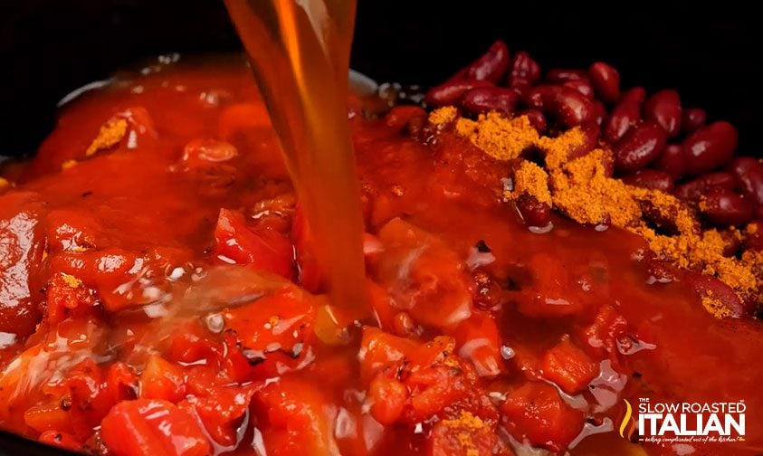 pouring beef stock into slow cooker