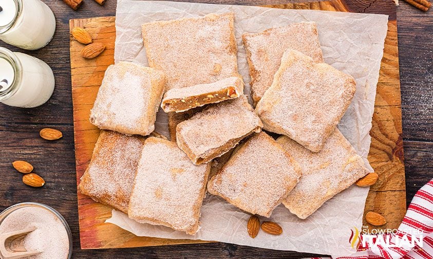 pile of churro toffee squares on a parchment lined cutting board