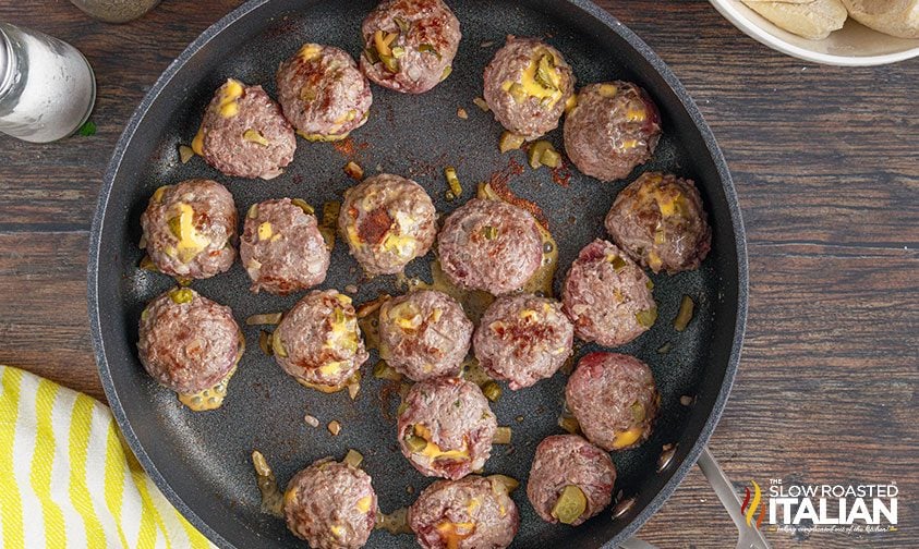 browning cheese stuffed meatballs in skillet