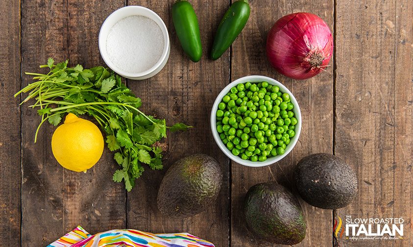 healthy guacamole recipe ingredients in bowls on wooden counter