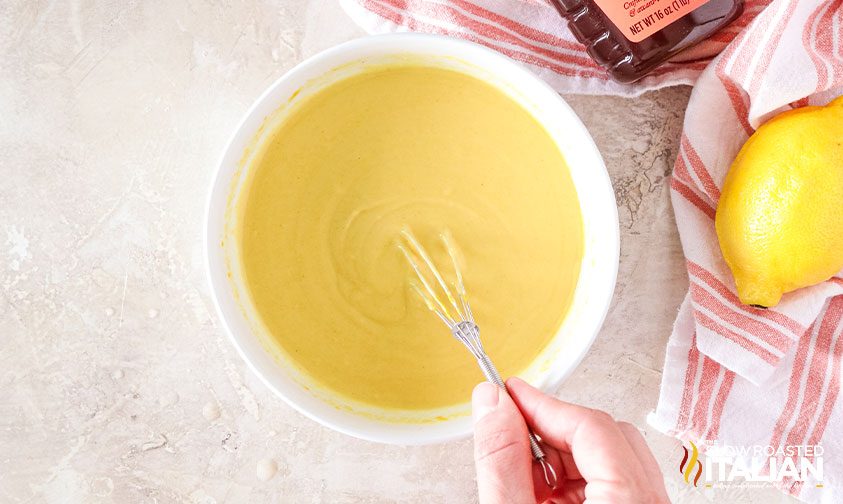 whisking ingredients in bowl for honey mustard recipe