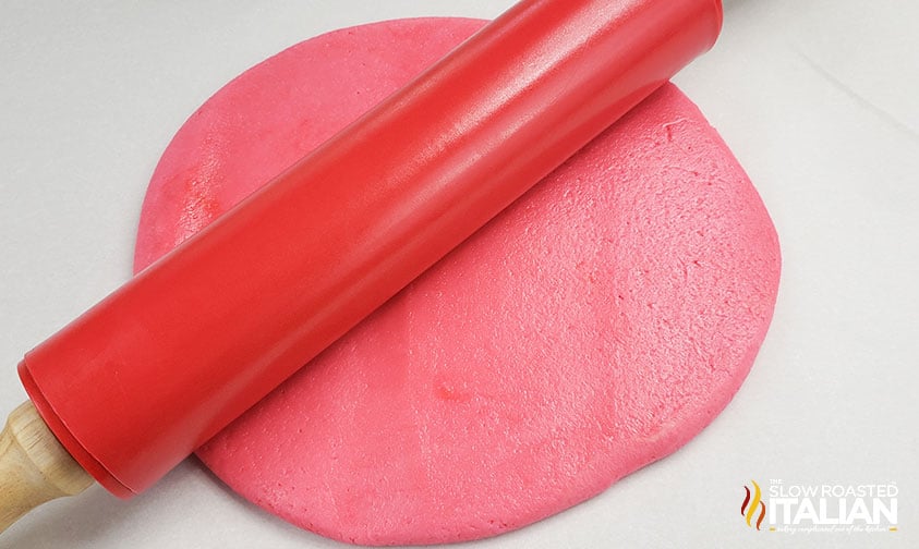 rolling out pink sugar cookie dough