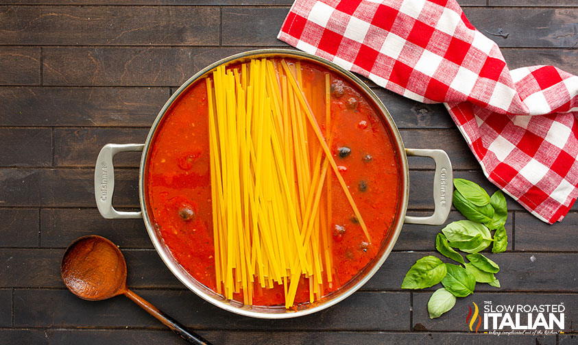 adding pasta to sauce