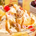 close up: bowl of creamy pineapple dessert salad with cherries and caramel