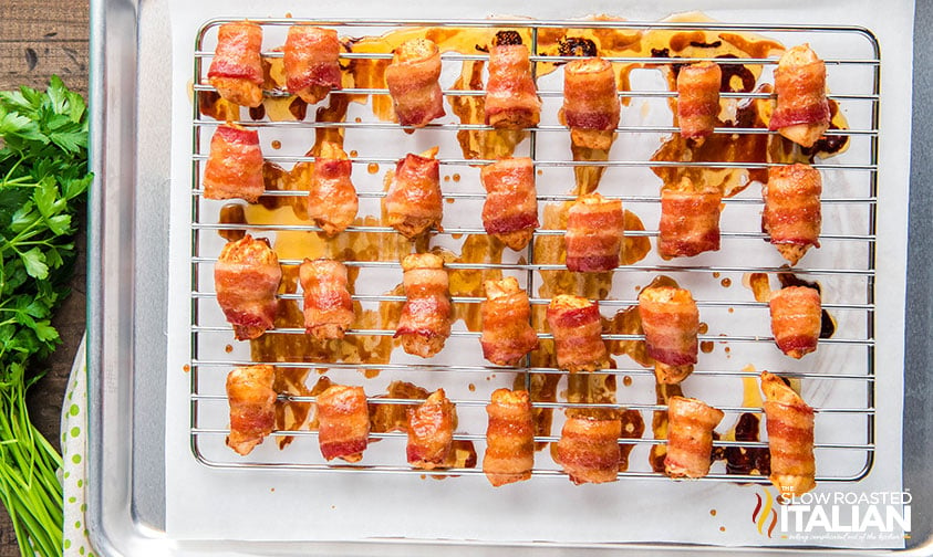 baked bacon wrapped chicken bites on a baking sheet