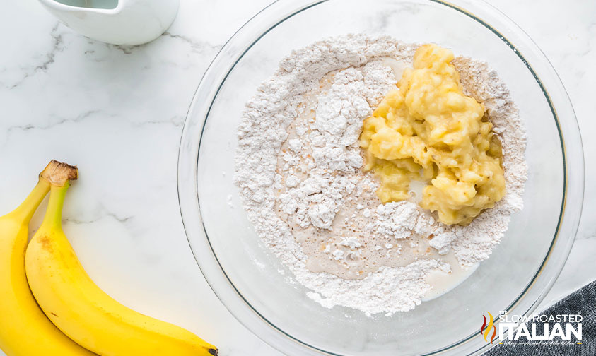 mashed banana and dry ingredients in a mixing bowl