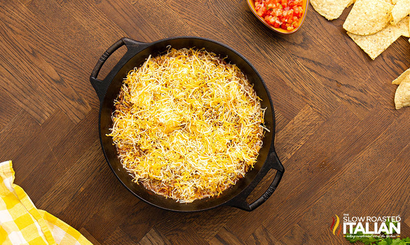 topping ground beef mixture with shredded cheese
