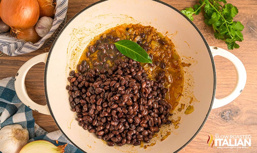 adding black beans to large pot