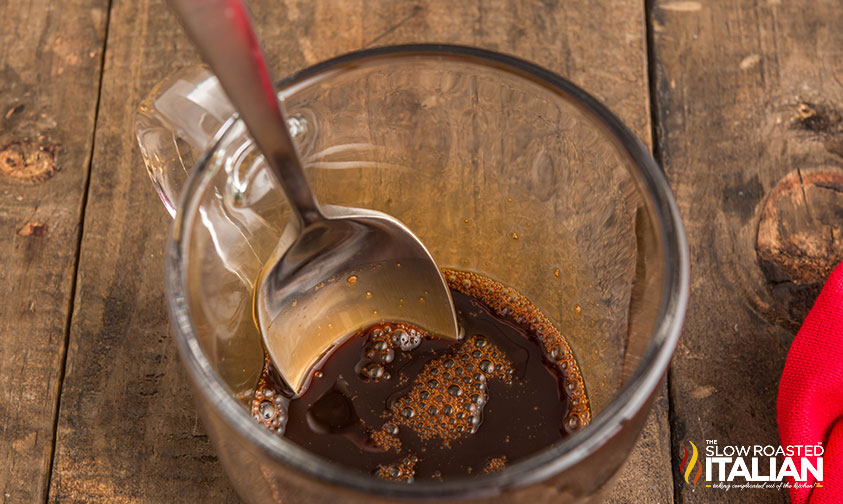 combining maple syrup and espresso in a glass measuring cup