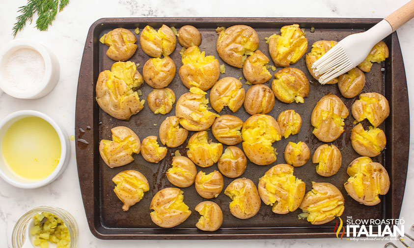 smashing potatoes with a fork on a baking sheet