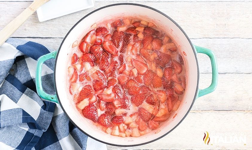 simmering strawberries, apples, sugar, and orange juice in large pot