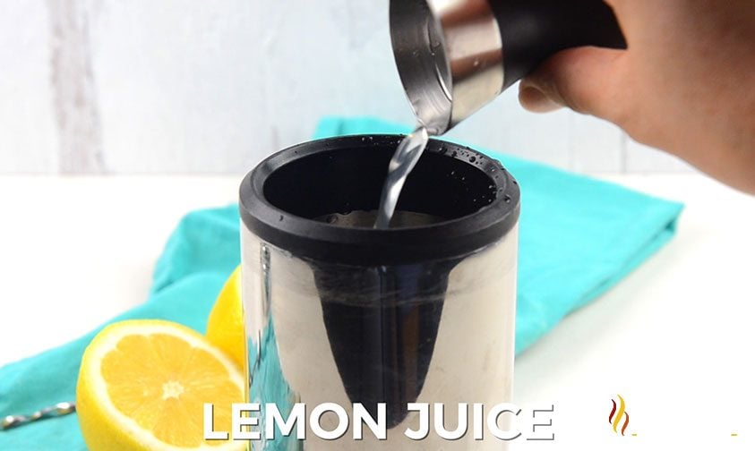 pouring clear liquid into cocktail shaker, white text along bottom says lemon juice