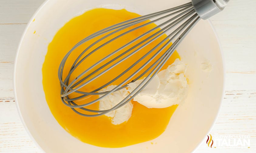 combining cream cheese and eggs in a mixing bowl