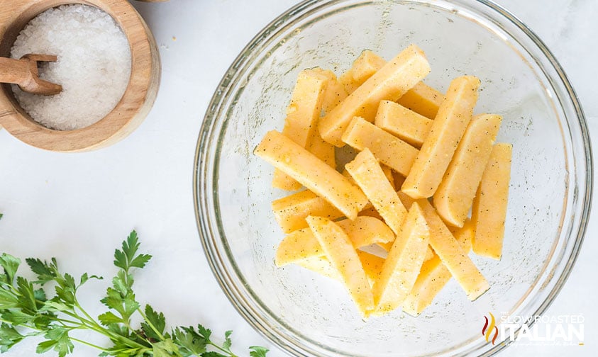 polenta fries seasoned in a large bowl