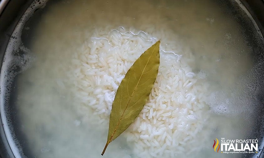 rice in a pot with a bay leaf