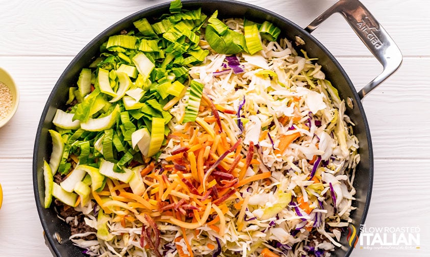coleslaw mix added to ground beef in a large skillet