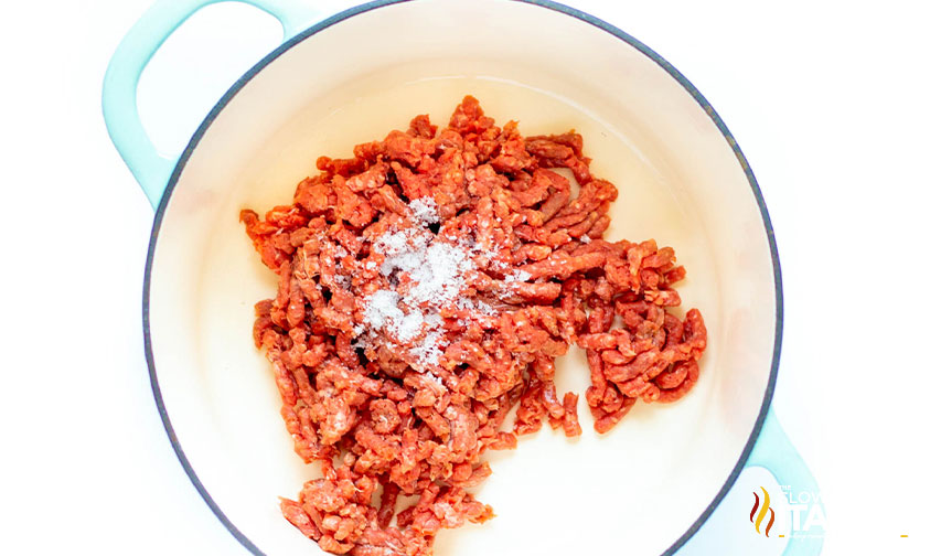 cooking ground beef seasoned with salt in a dutch oven