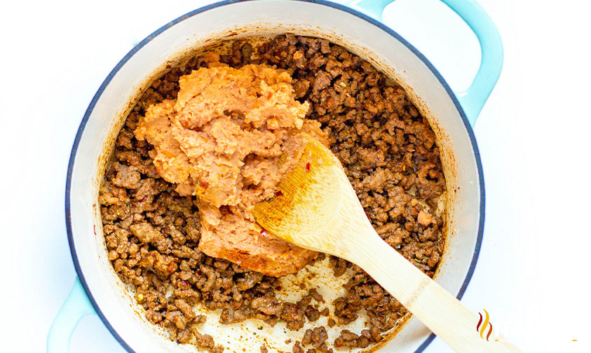 adding refried beans to ground beef