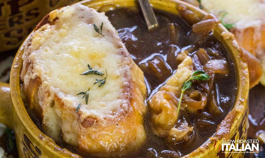 crock of French onion soup topped with cheese covered baguette slice