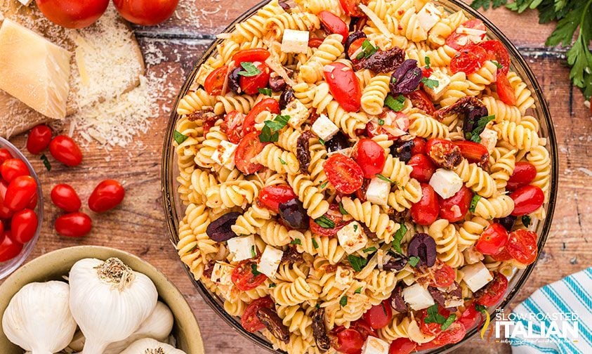 overhead: big bowl of pasta salad with feta cheese, olives, and tomatoes