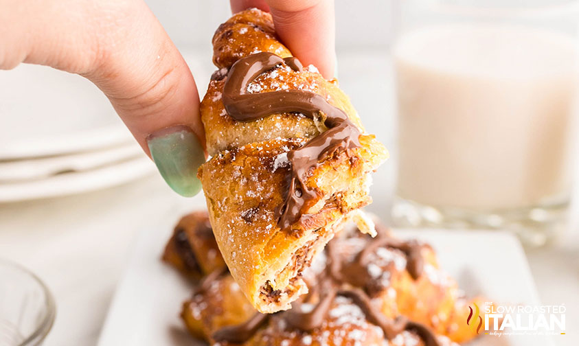 hand holding half of a nutella croissant