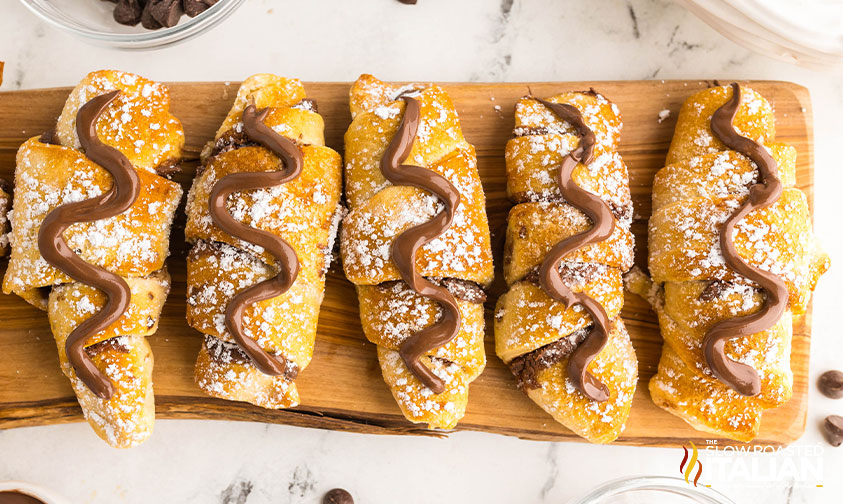 nutella croissants with a drizzle and powdered sugar on top