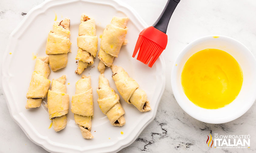 brushing nutella croissants with an egg wash