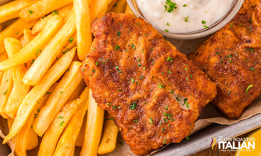 air fryer fish and chips on a small baking tray with tartar sauce