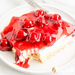 cherry cheesecake lush dessert on a plate with bite missing