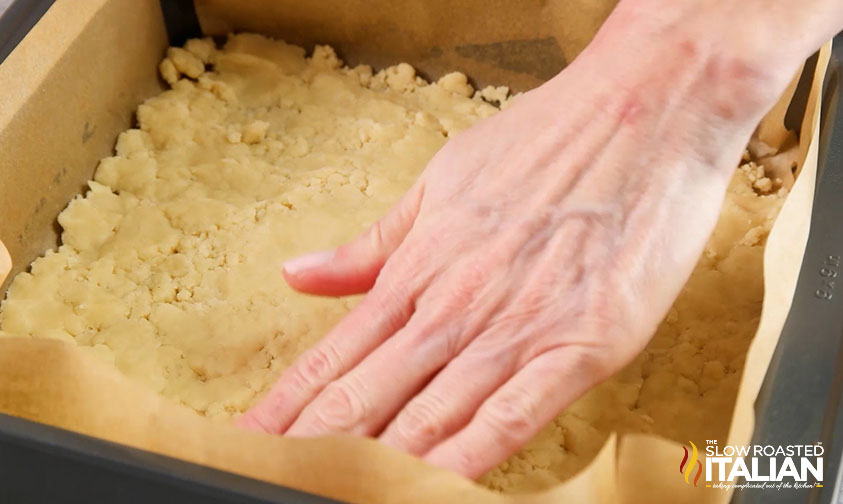 pressing lemon bar crust into a baking pan