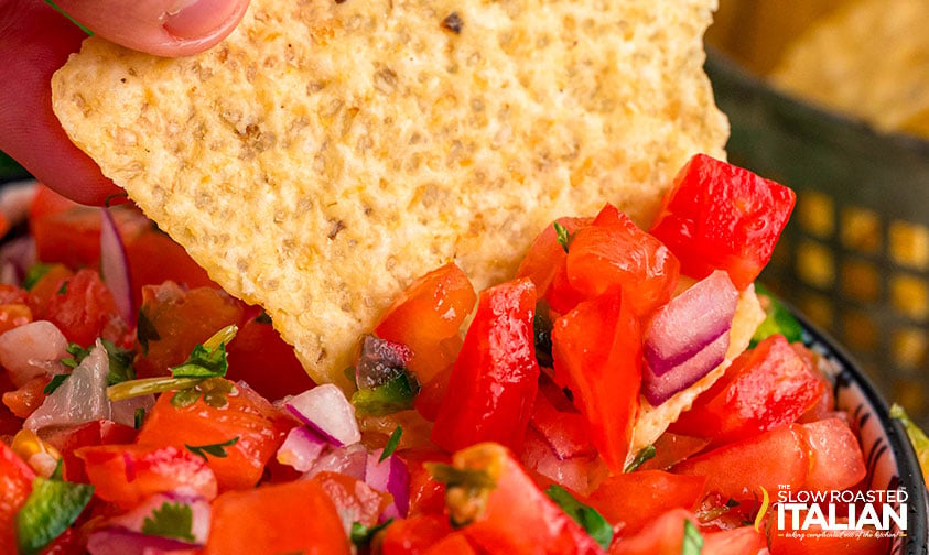 tortilla chip dipped in fresh tomato salsa