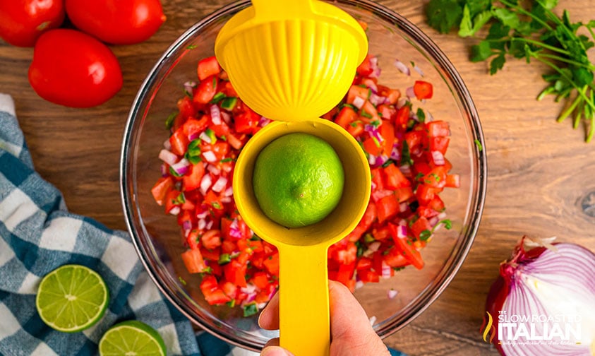 squeezing fresh lime juice on chipotle tomato salsa copycat