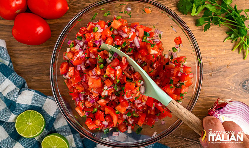 mixing fresh tomato salsa