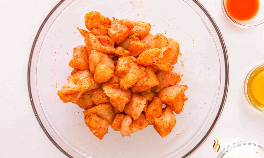 tossing chicken pieces in seasoning mix