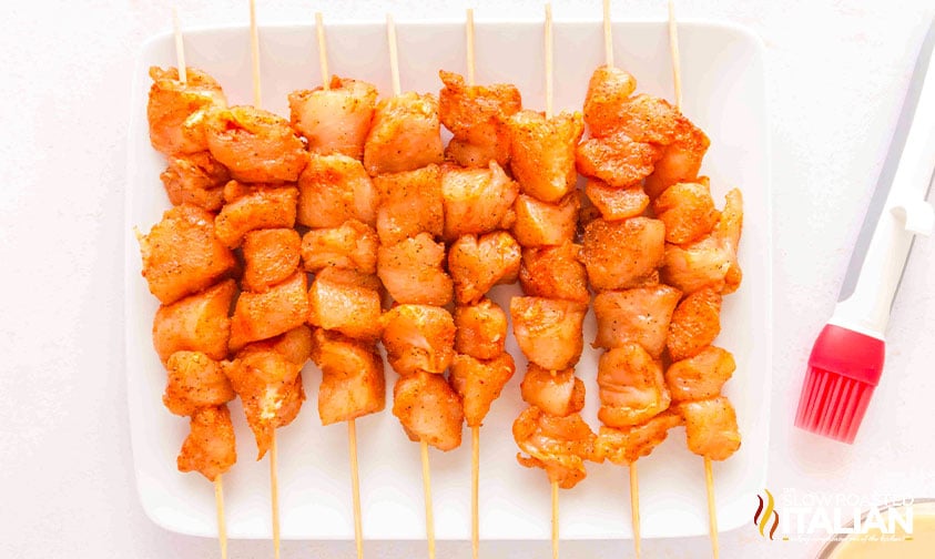 seasoned bang bang chicken pieces on wooden skewers