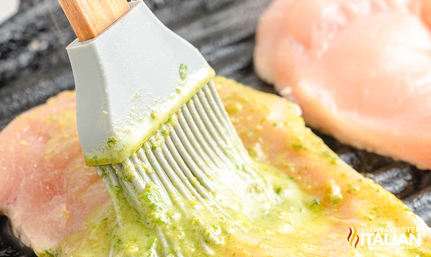 brushing chicken breasts with pesto