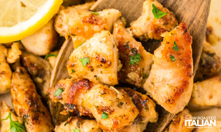 closeup of garlic butter chicken bites on a wooden spoon